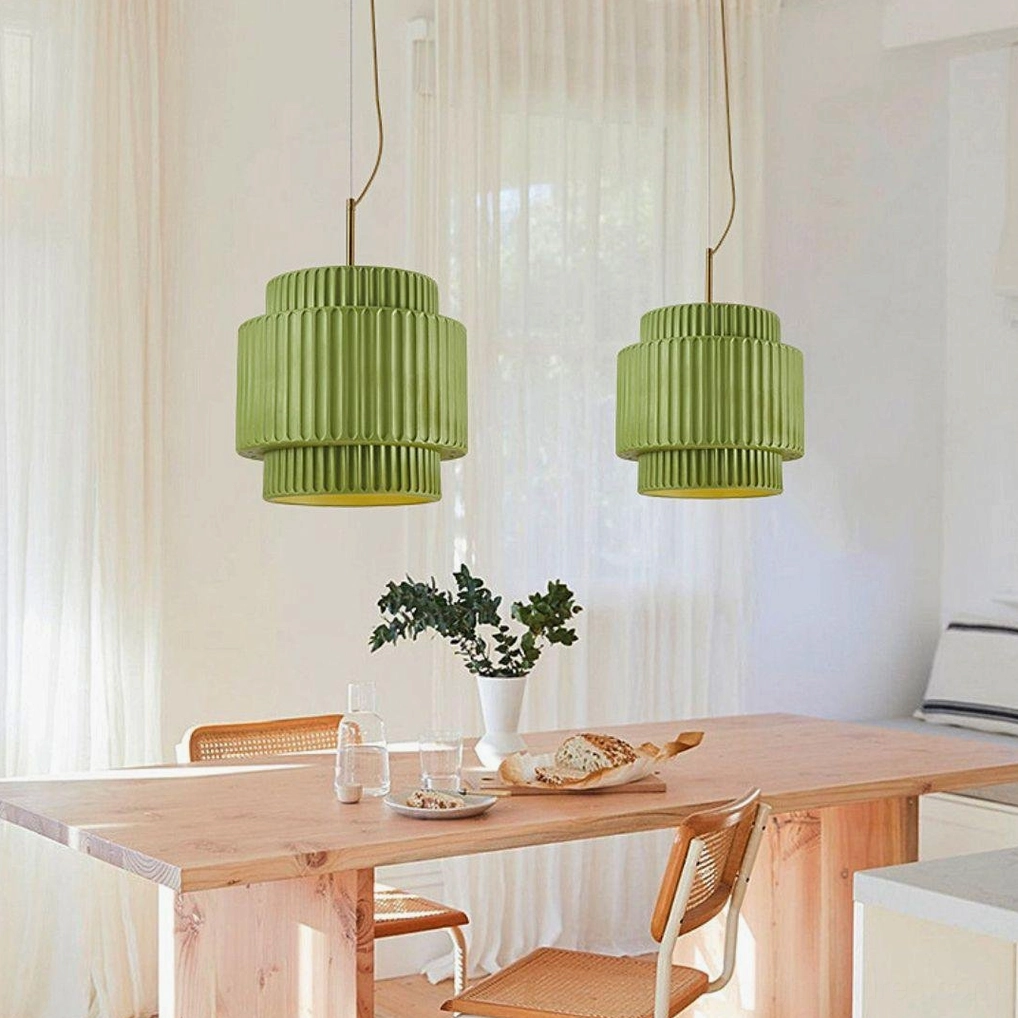 Pair of green Nyla pendant lights, side angle view in farmhouse dining room with wood table