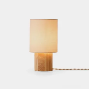 Modern cylindrical oak wood table lamp with beige fabric shade on white background - minimalist Scandinavian design