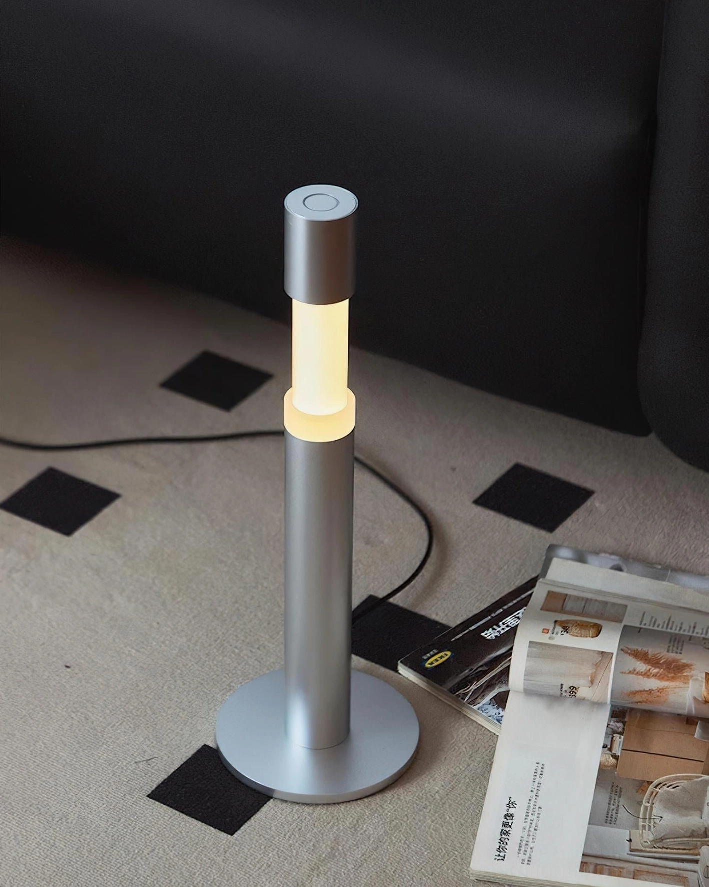 Obelisk minimalist table lamp lit ambient glow low angle view carpeted living room setting