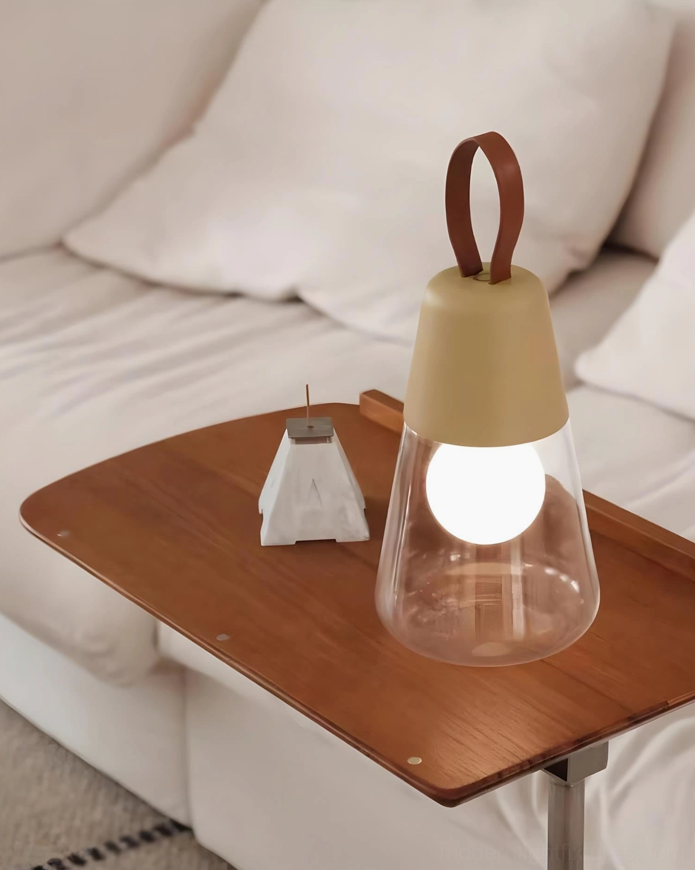 Khaki Oceana portable table lamp with warm illuminated bulb on foldable wooden side table in living room