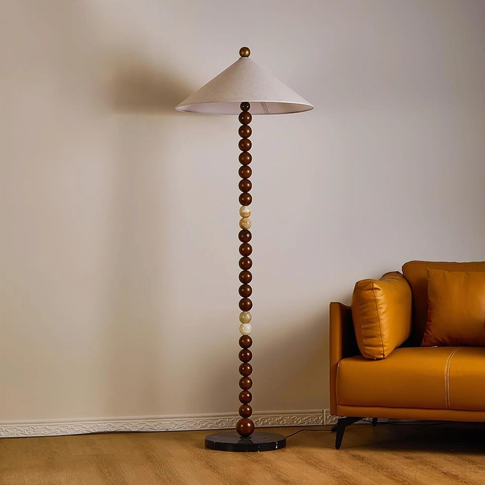Octavia floor lamp in living room, three-quarter view showing walnut color pole and marble base with fabric shade