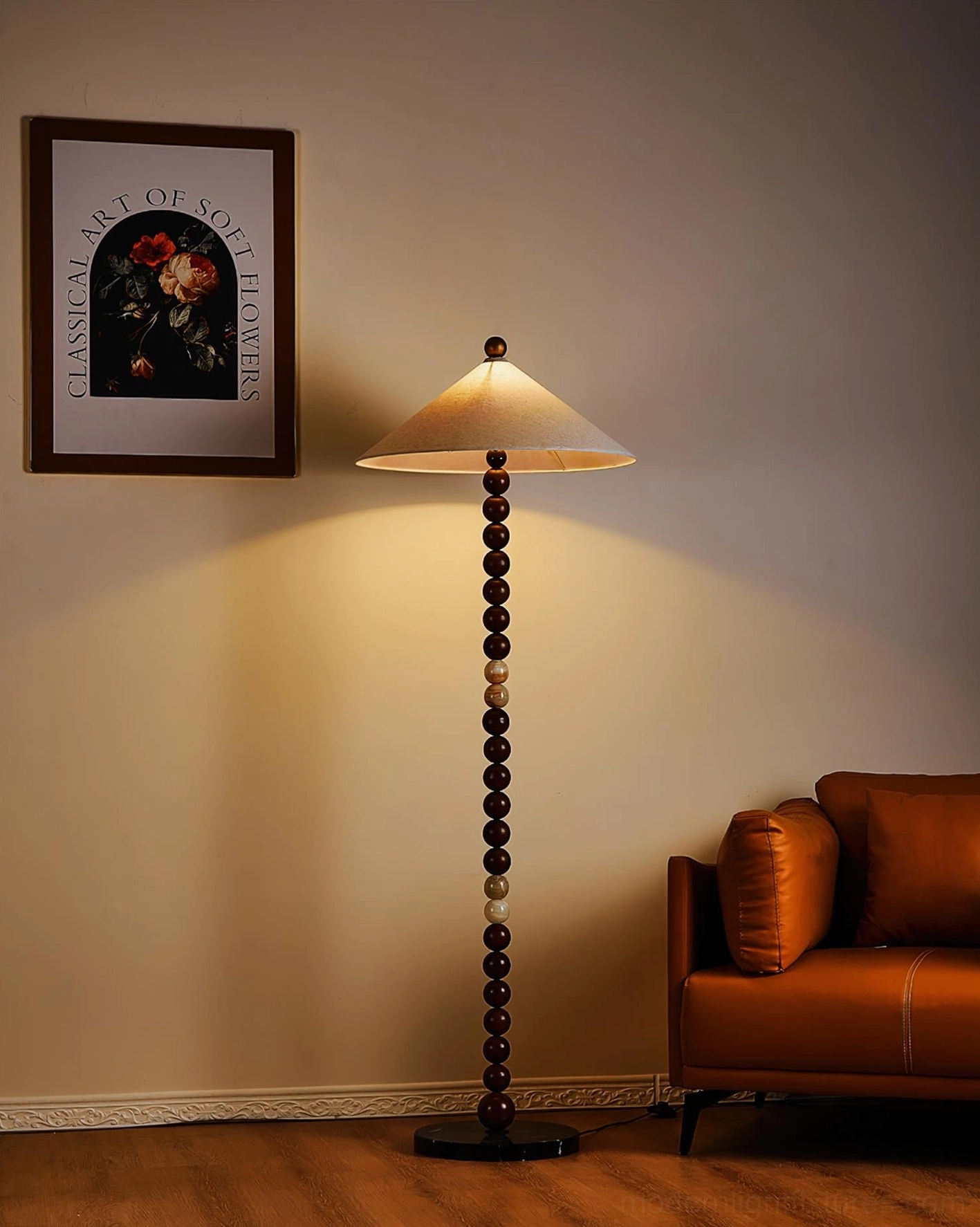 Illuminated Octavia floor lamp casting warm ambient light in residential living room with leather sofa