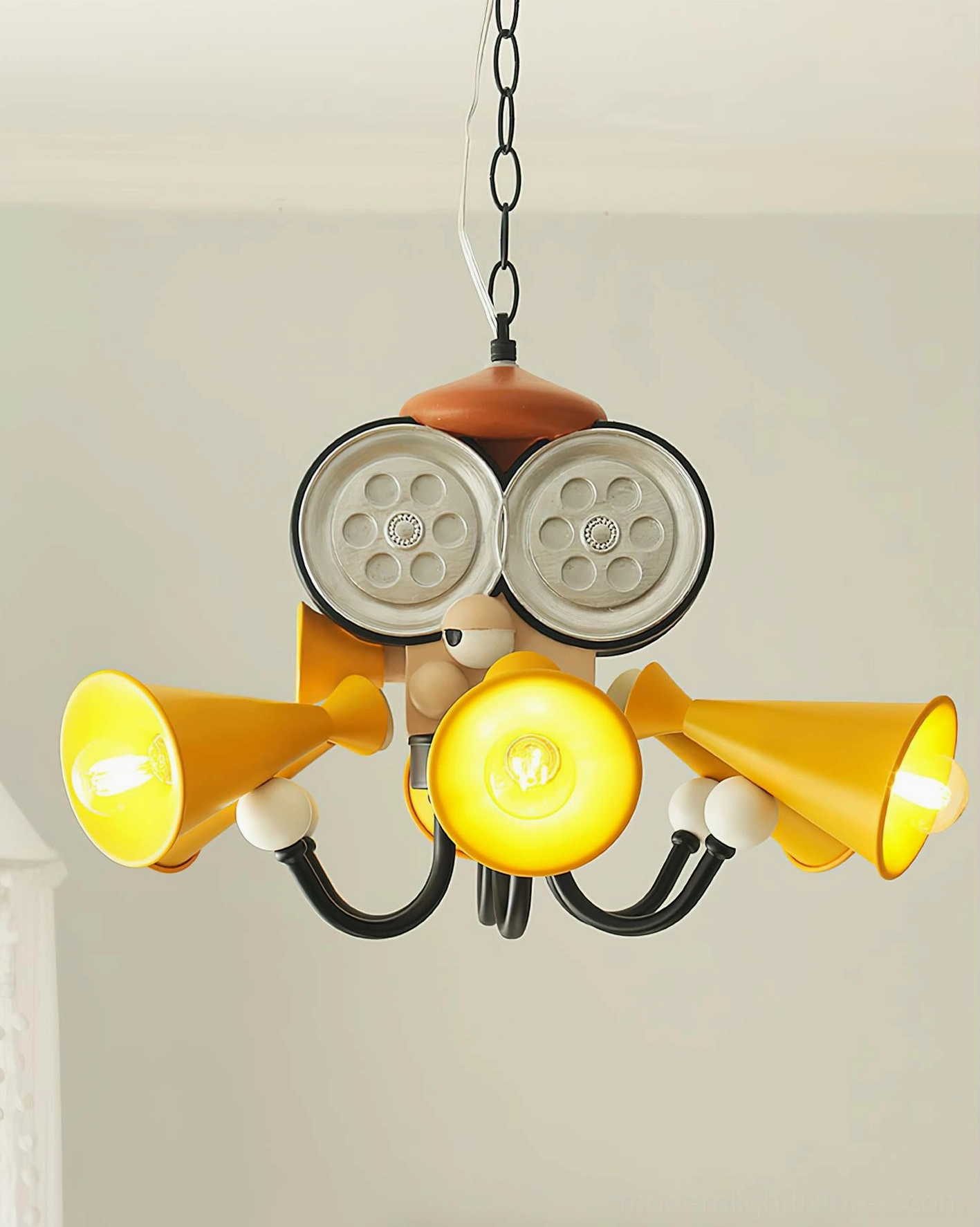 Overhead view of lit octopus director chandelier with warm yellow glowing bulbs and black metal framework