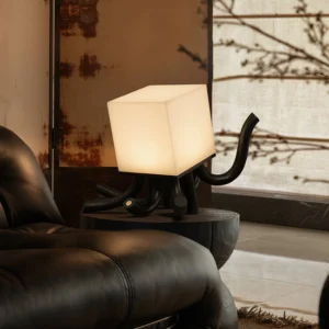 Modern wooden octopus table lamp in contemporary living room with leather sofa, warm ambient lighting creating wabi-sabi minimalist atmosphere