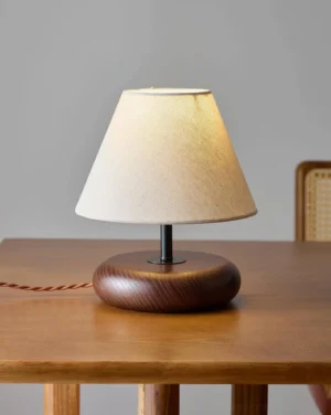 Modern Olen table lamp positioned on wooden dining table with warm ambient lighting and orange power cord