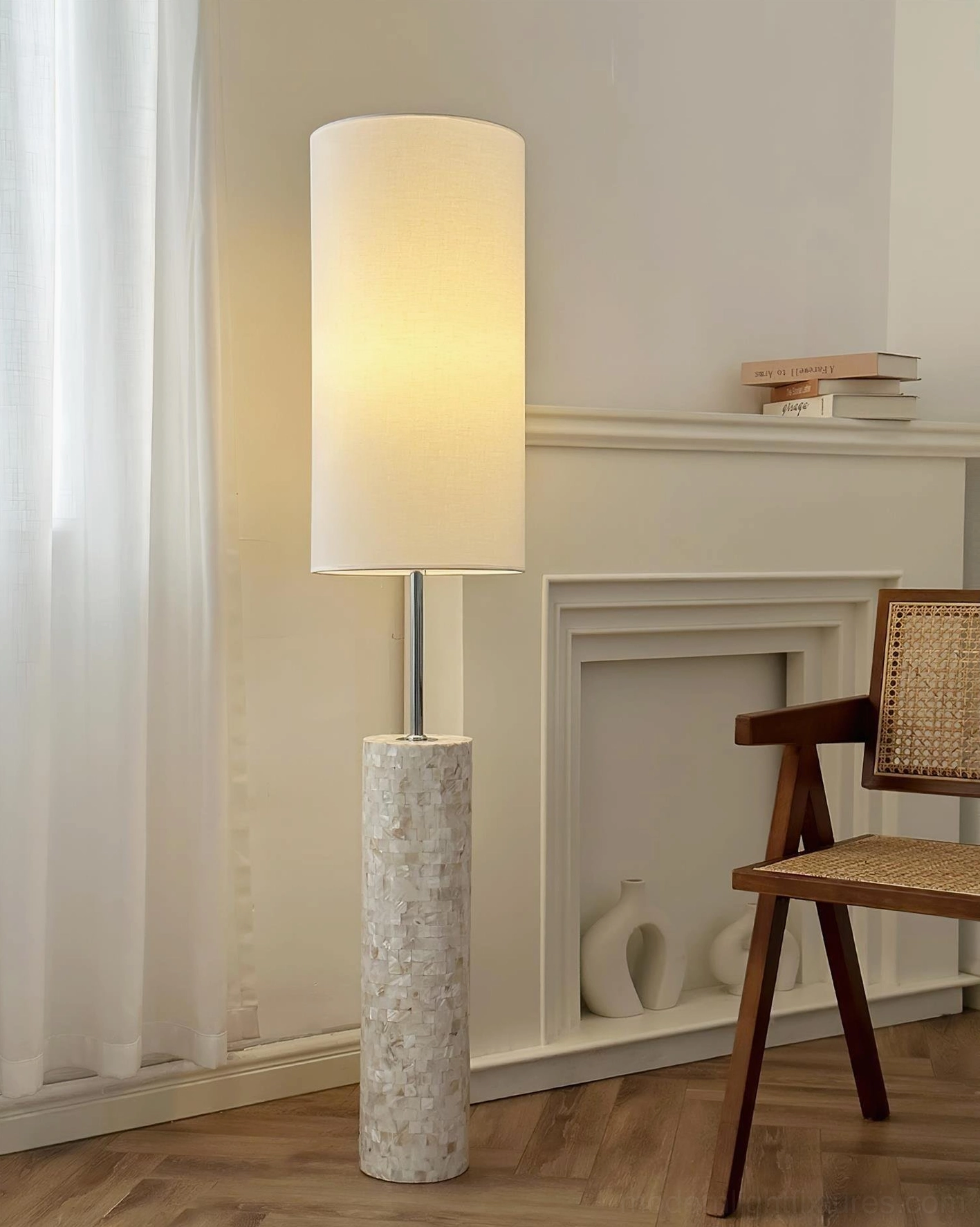Ollie floor lamp in warm fireplace living room setting with wooden flooring and rattan chair