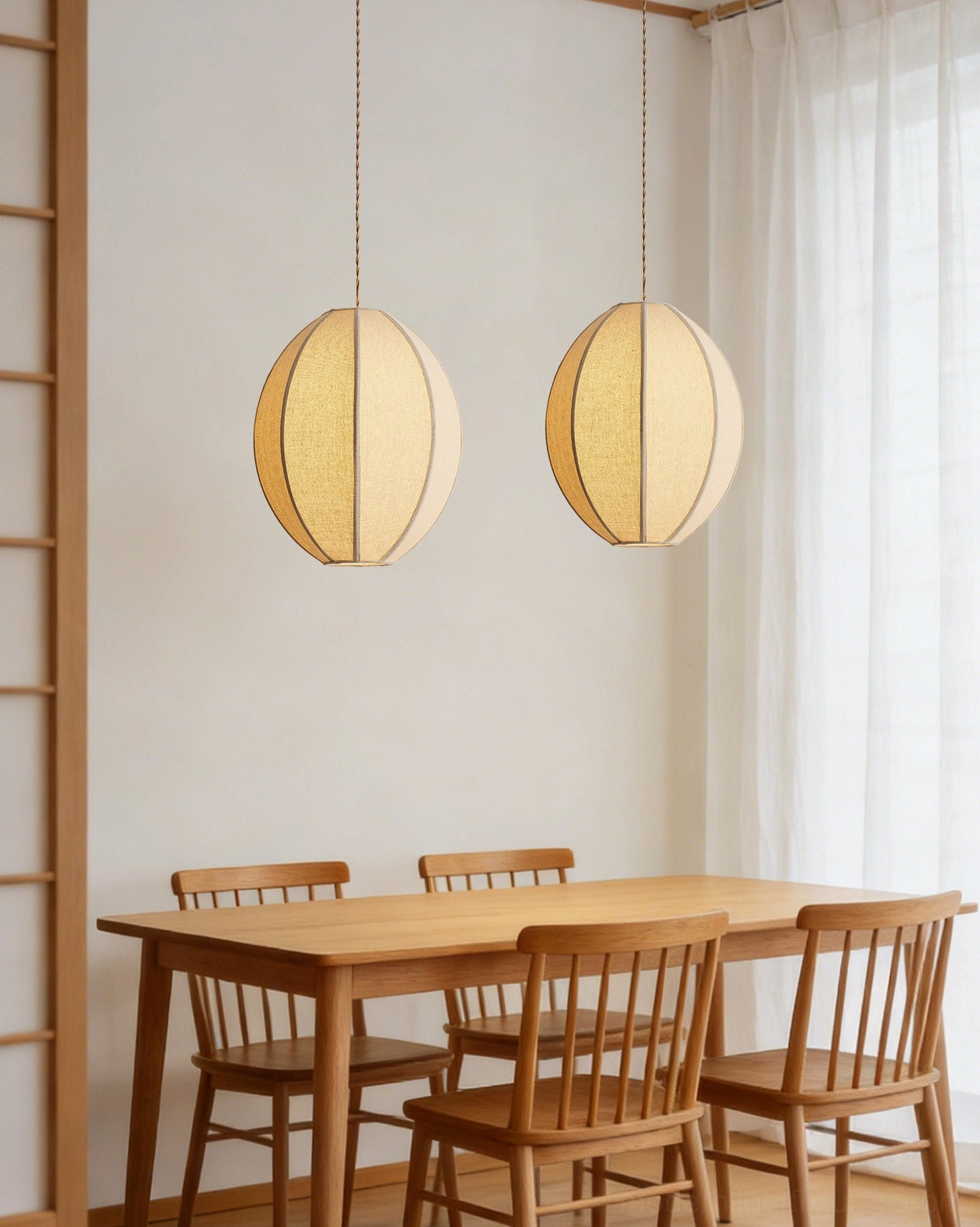 Pair of Omra fabric pendant lights in Japanese-style dining room with wooden furniture, minimalist linen lantern design with warm lighting
