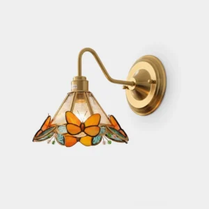Orange butterfly stained glass wall sconce with brass frame, front view in studio lighting