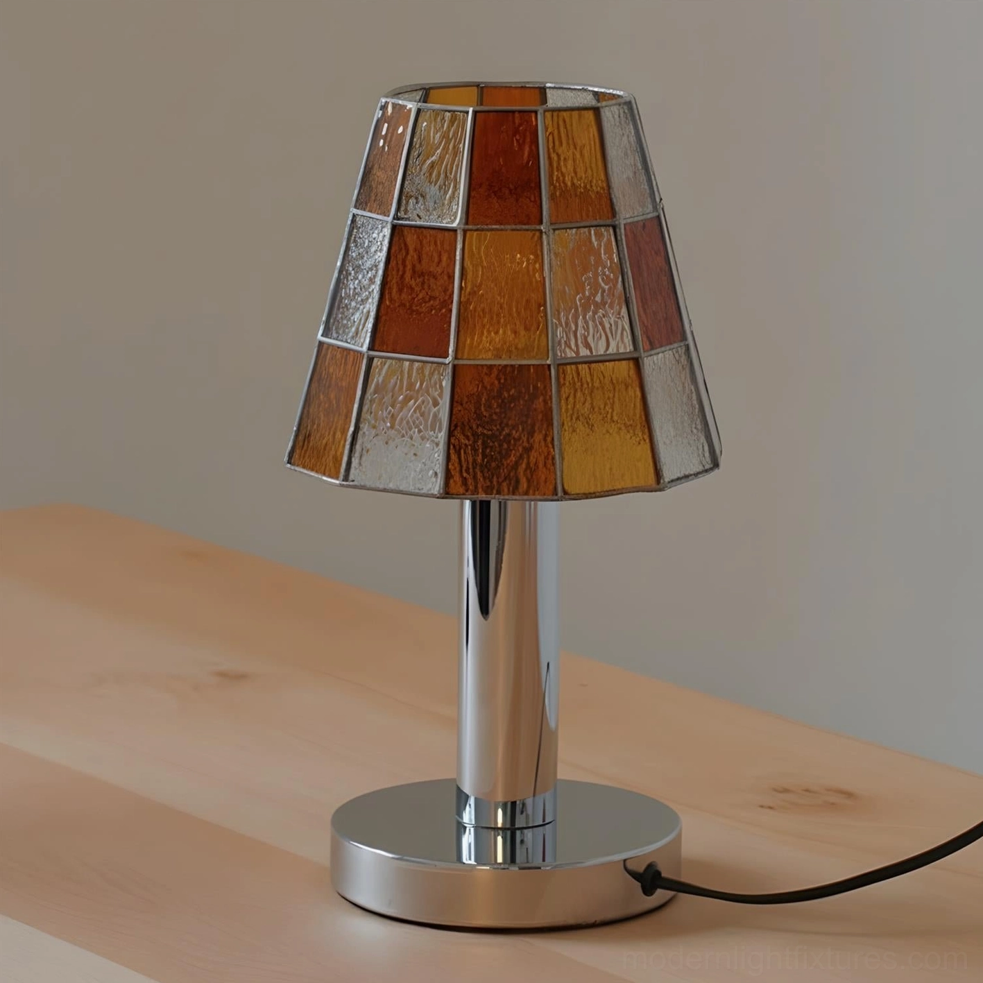 Warm-toned orange stained glass table lamp with geometric pattern and chrome metal base, side view