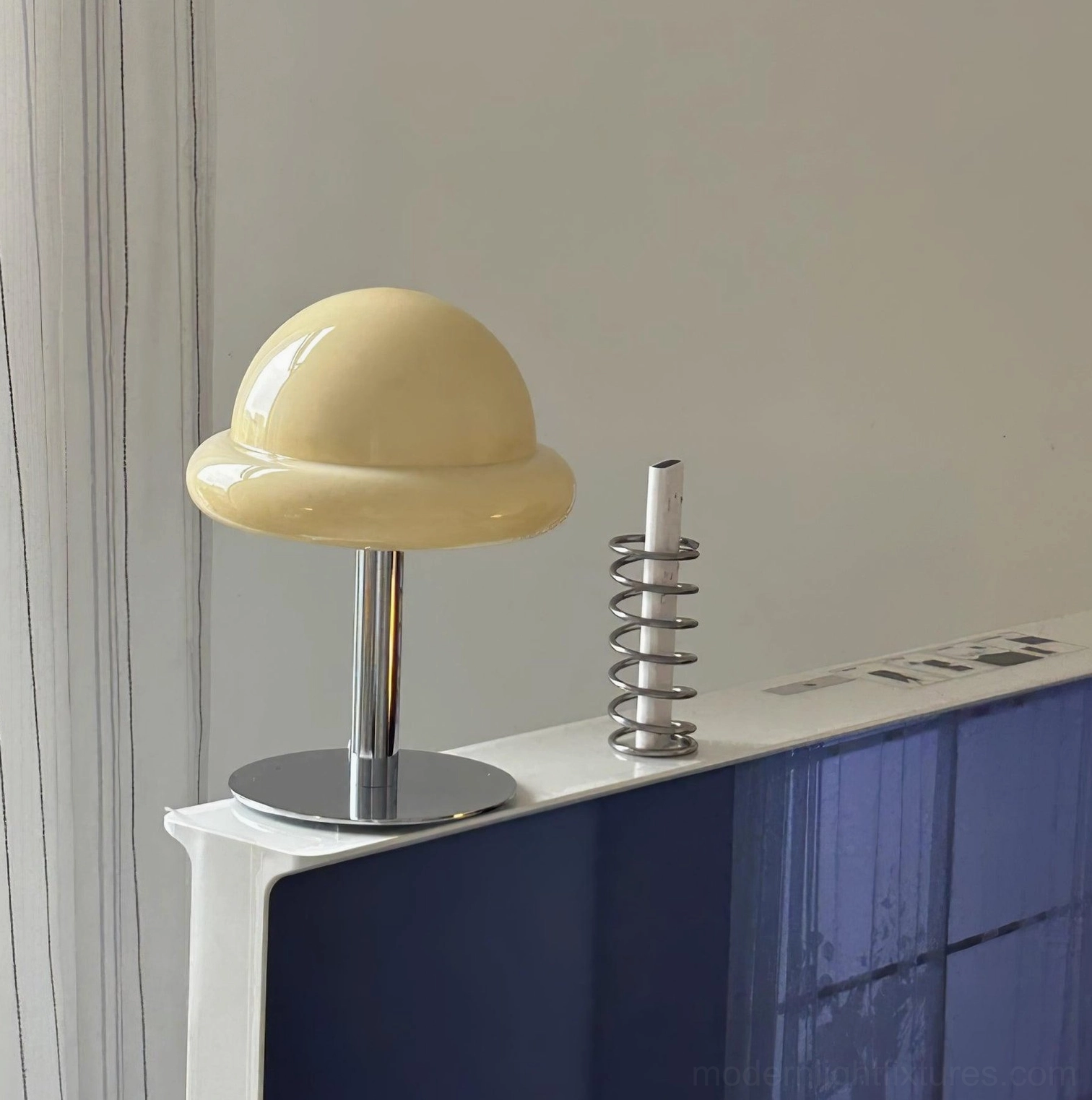Orange mushroom glass table lamp with polished chrome stand on living room display table