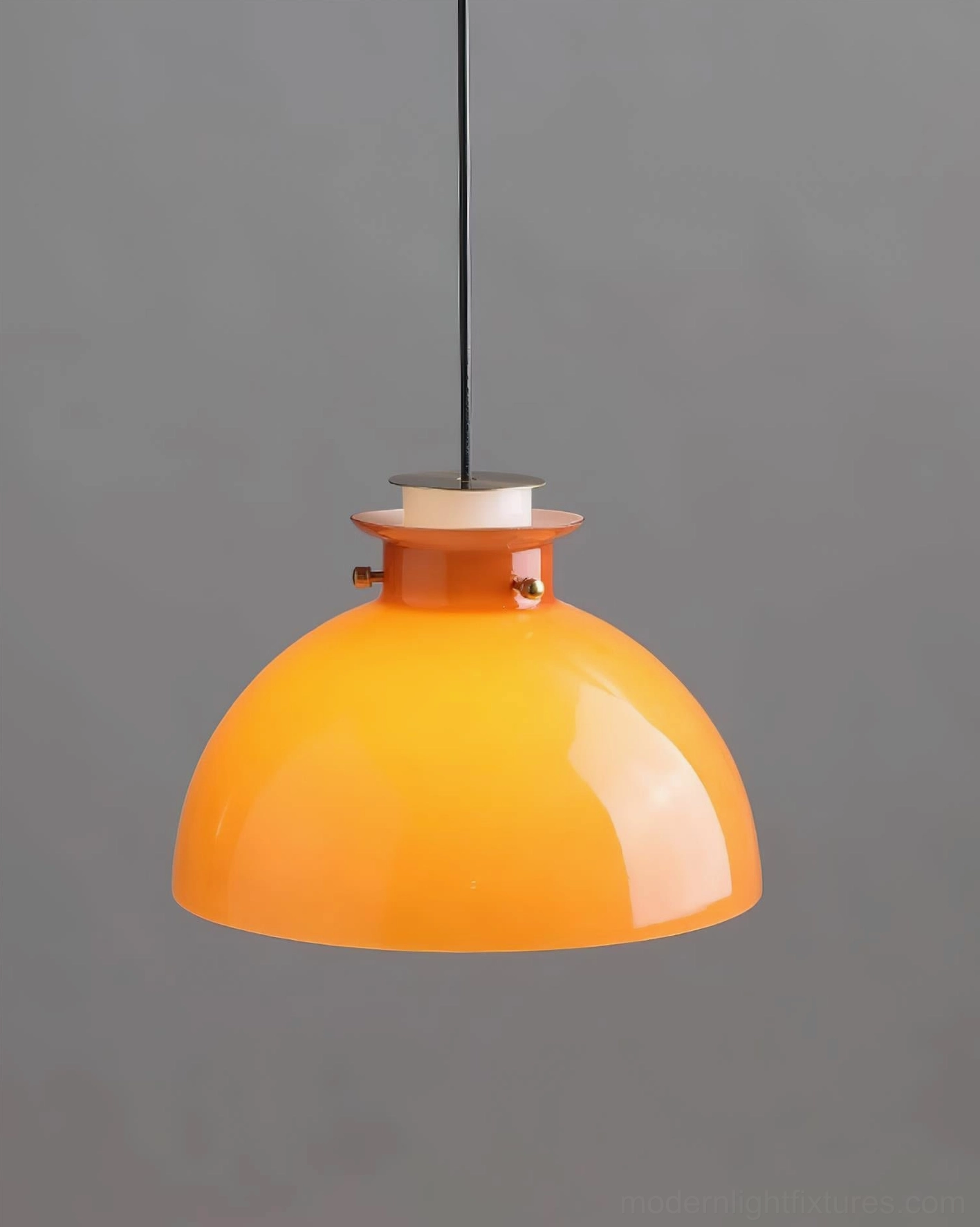 Orange dome pendant light installed above table or counter, residential application
