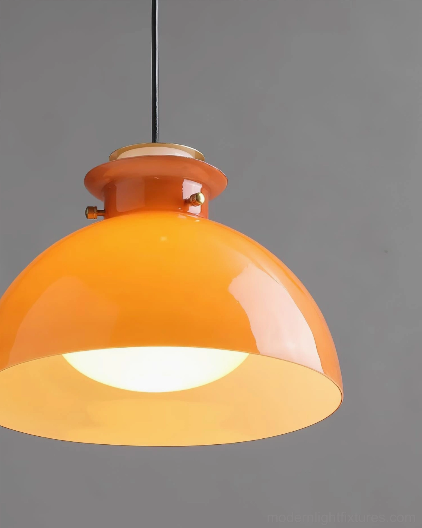 Orange pendant light with focused downward beam, accent lighting for task areas