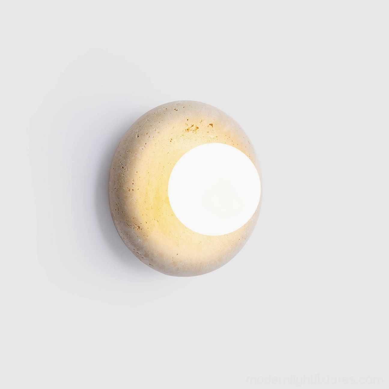 Minimalist orb wall sconce with beige travertine and white glass, glowing warm light, studio shot