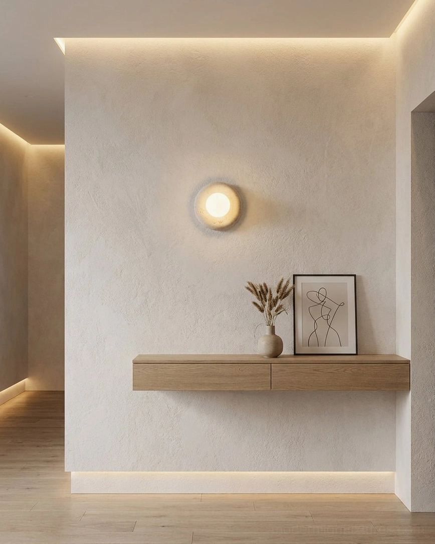 Orb wall sconce installed in modern minimalist entryway with floating wood shelf and neutral tones