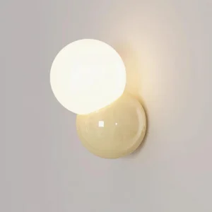 Orb wall sconce side close-up detail showing smooth glossy stacked spheres and metal base construction