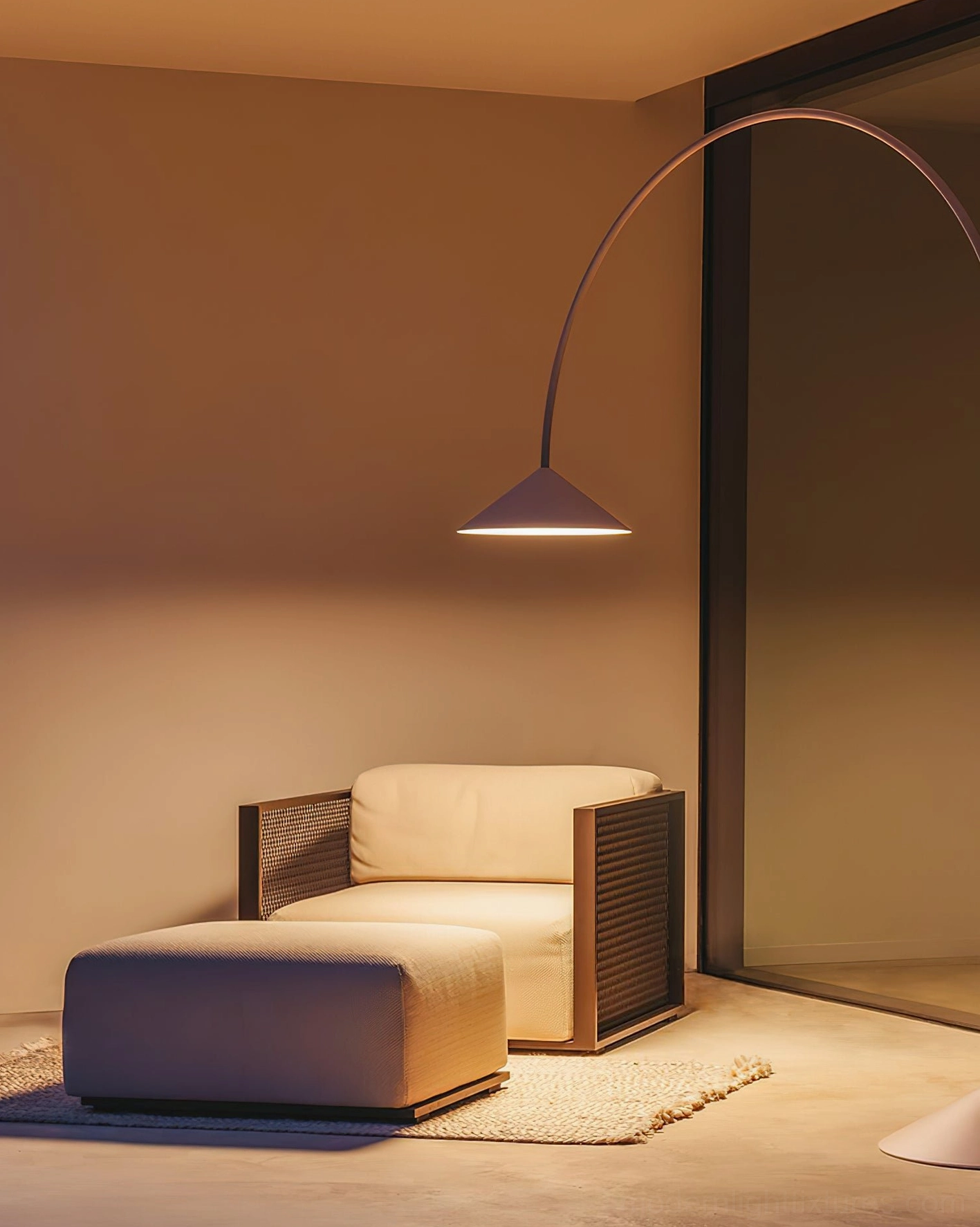 Dark matte Orbitas arc floor lamp side view in modern living room with warm glowing ambient light effect