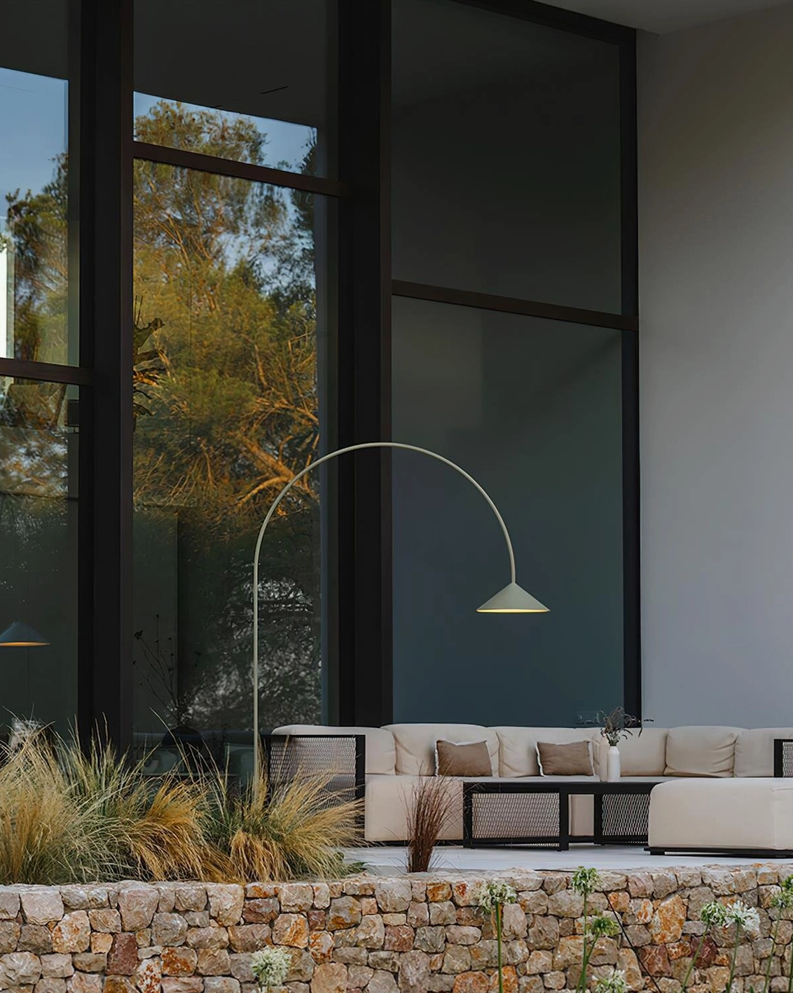 Orbitas modern arc floor lamp side view in contemporary outdoor lounge patio setting