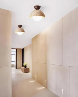 Multiple Orella travertine ceiling light fixtures installed in residential hallway corridor showing linear arrangement and warm light diffusion