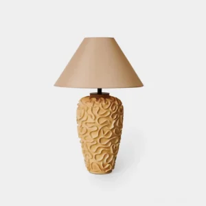 Organic ceramic table lamp with carved textured base and beige fabric shade, frontal studio view