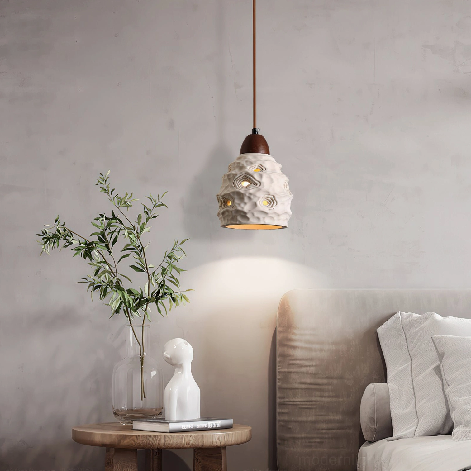 Single ceramic pendant lamp hanging in wabi-sabi living room corner with warm ambient lighting and textured porous shade