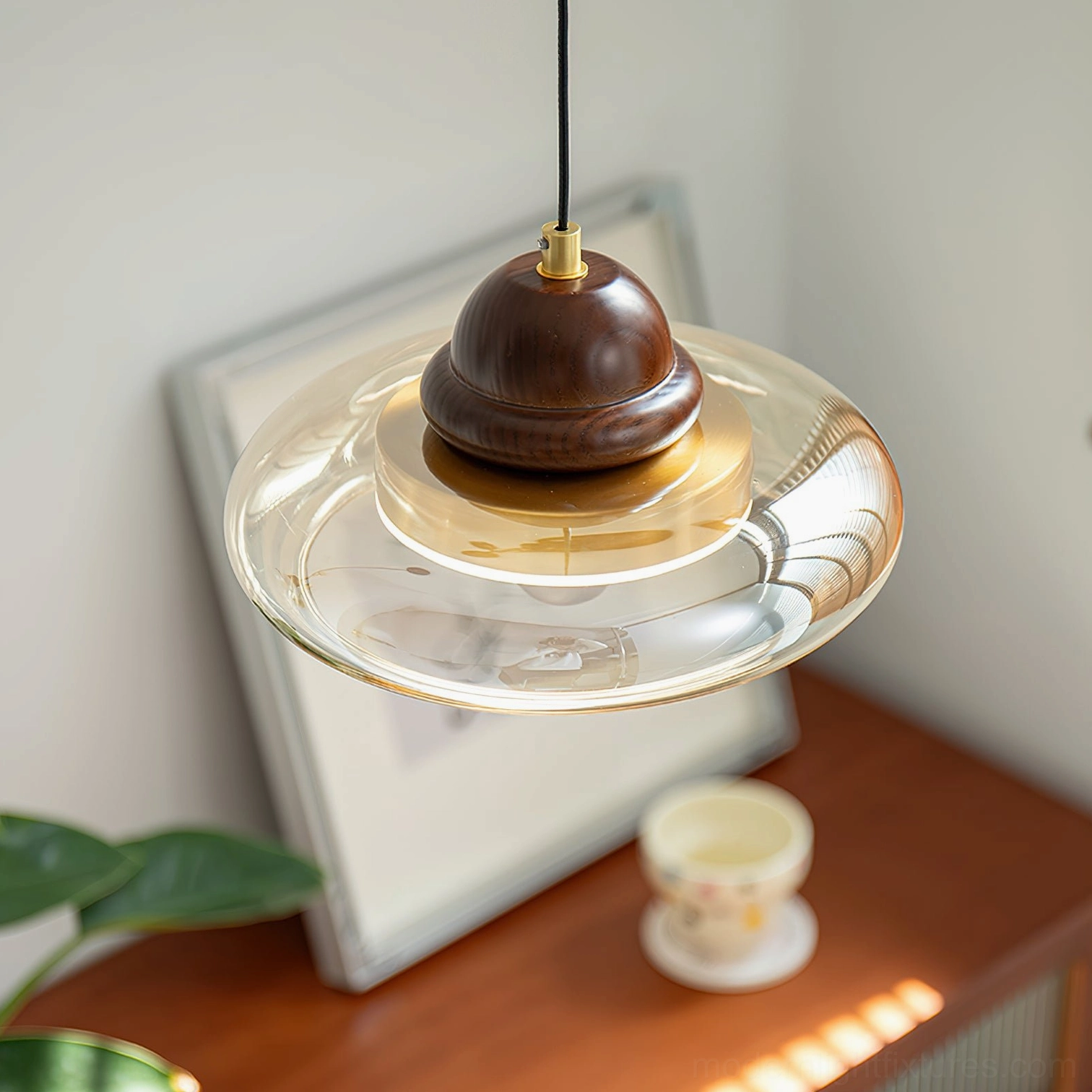 Close-up top-down view of Oria pendant lamp showing layered amber glass shade with brass accents