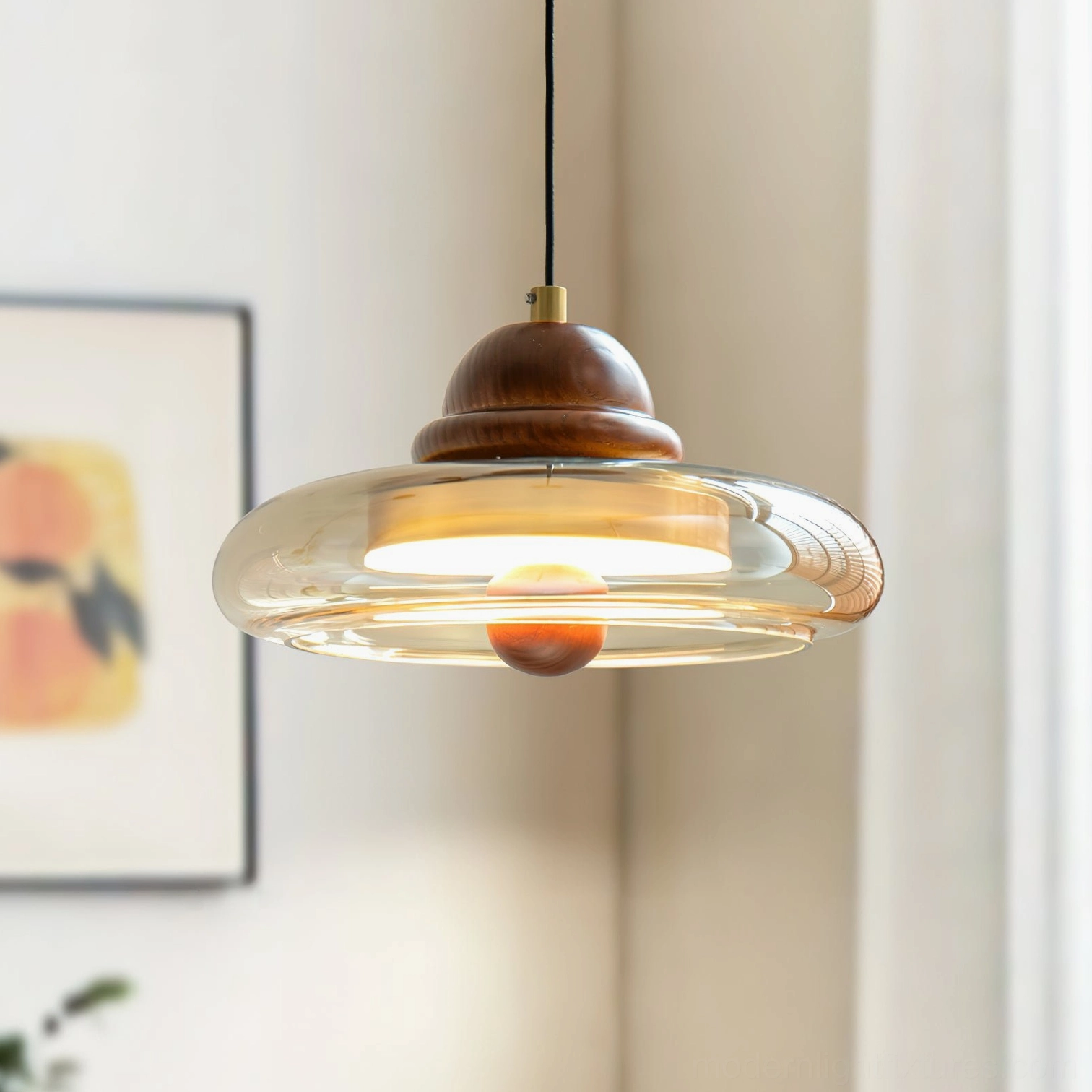 Oria pendant lamp in home interior showing warm cognac glass glow with black suspension cable