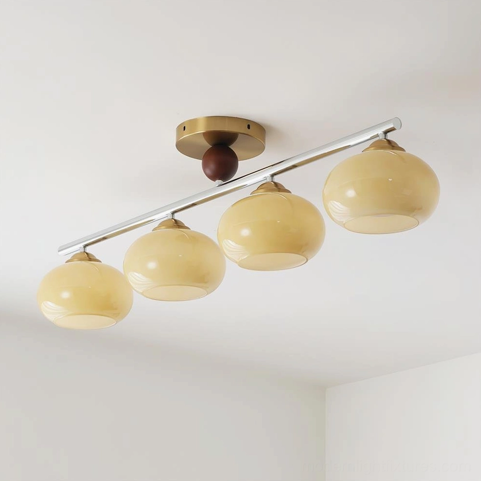 Orley linear ceiling light with gold metal finish and beige gradient glass globes in modern home