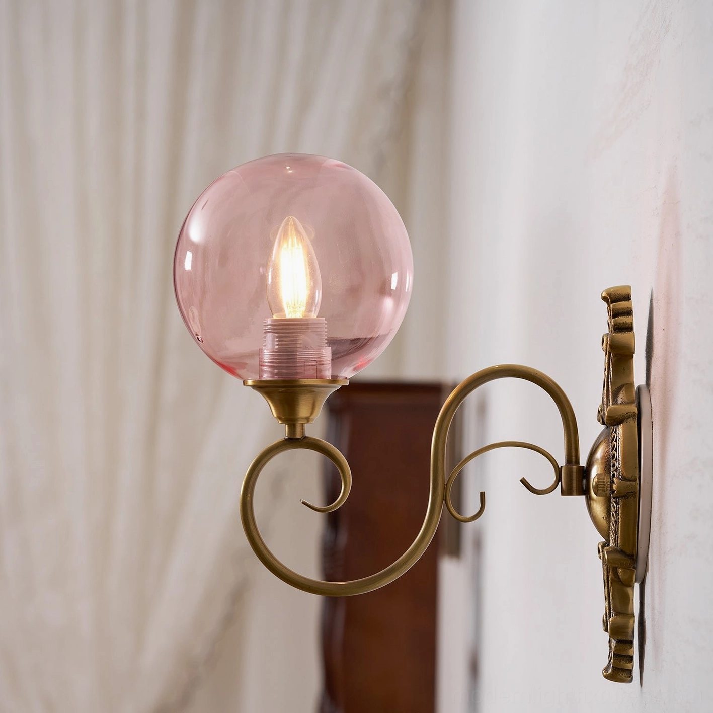 Ornate brass wall sconce showing metal curve and arm design, vintage baroque craftsmanship