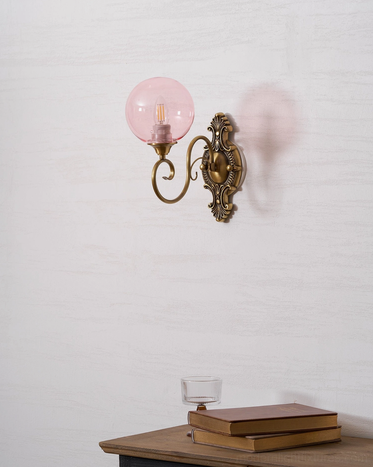 Hand-blown glass globe of ornate brass wall sconce, clear glass detail photograph