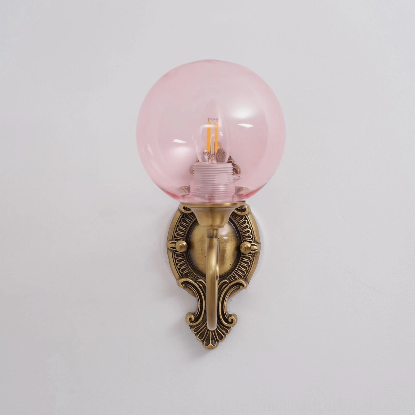 Ornate brass wall sconce mounted installation showing proper height and positioning
