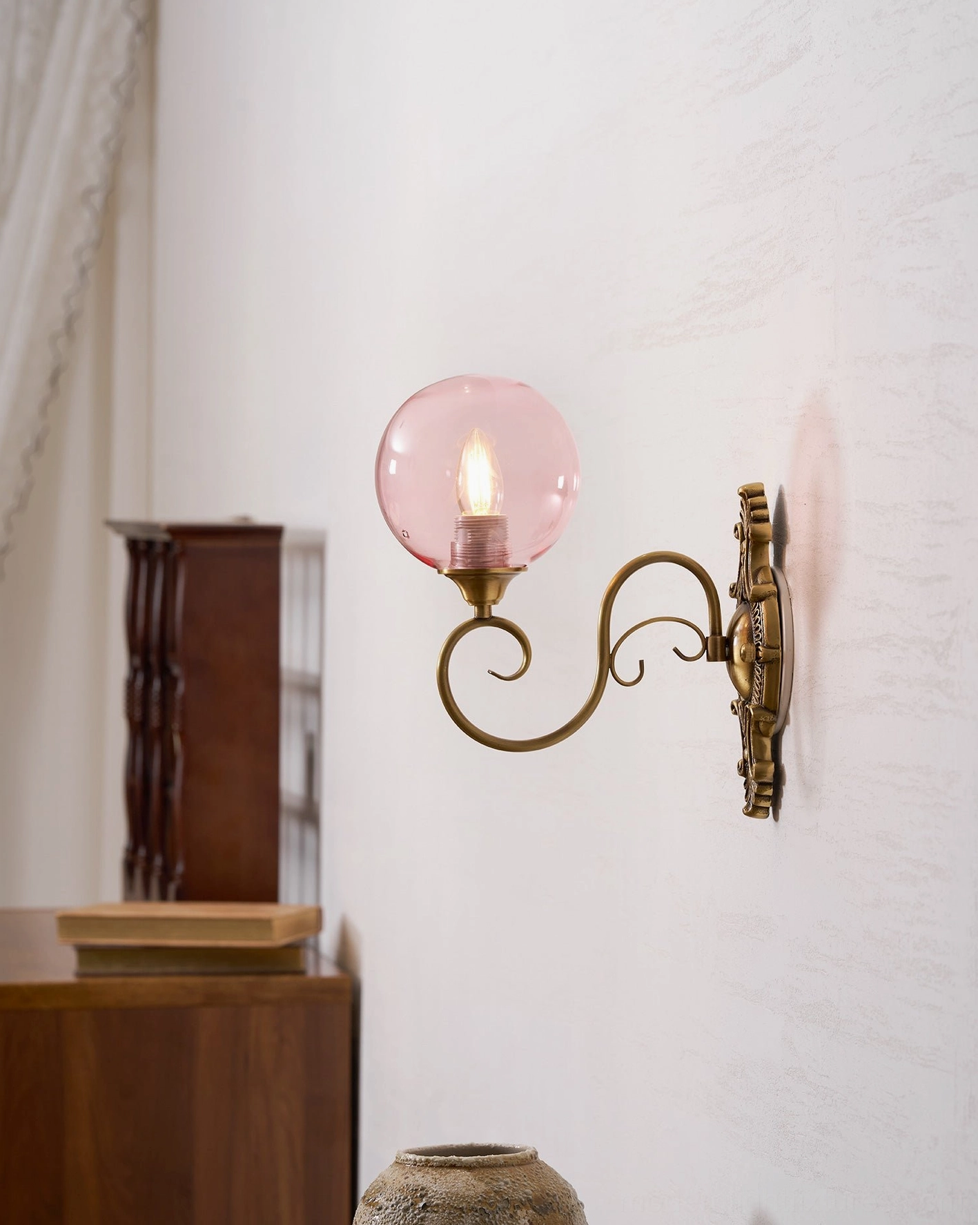Complete ornate brass wall sconce assembly with globe installed, vintage fixture mounted