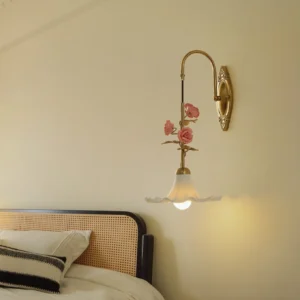 Ornella vintage-style wall lamp illuminated in bedroom setting with French provincial rattan headboard background