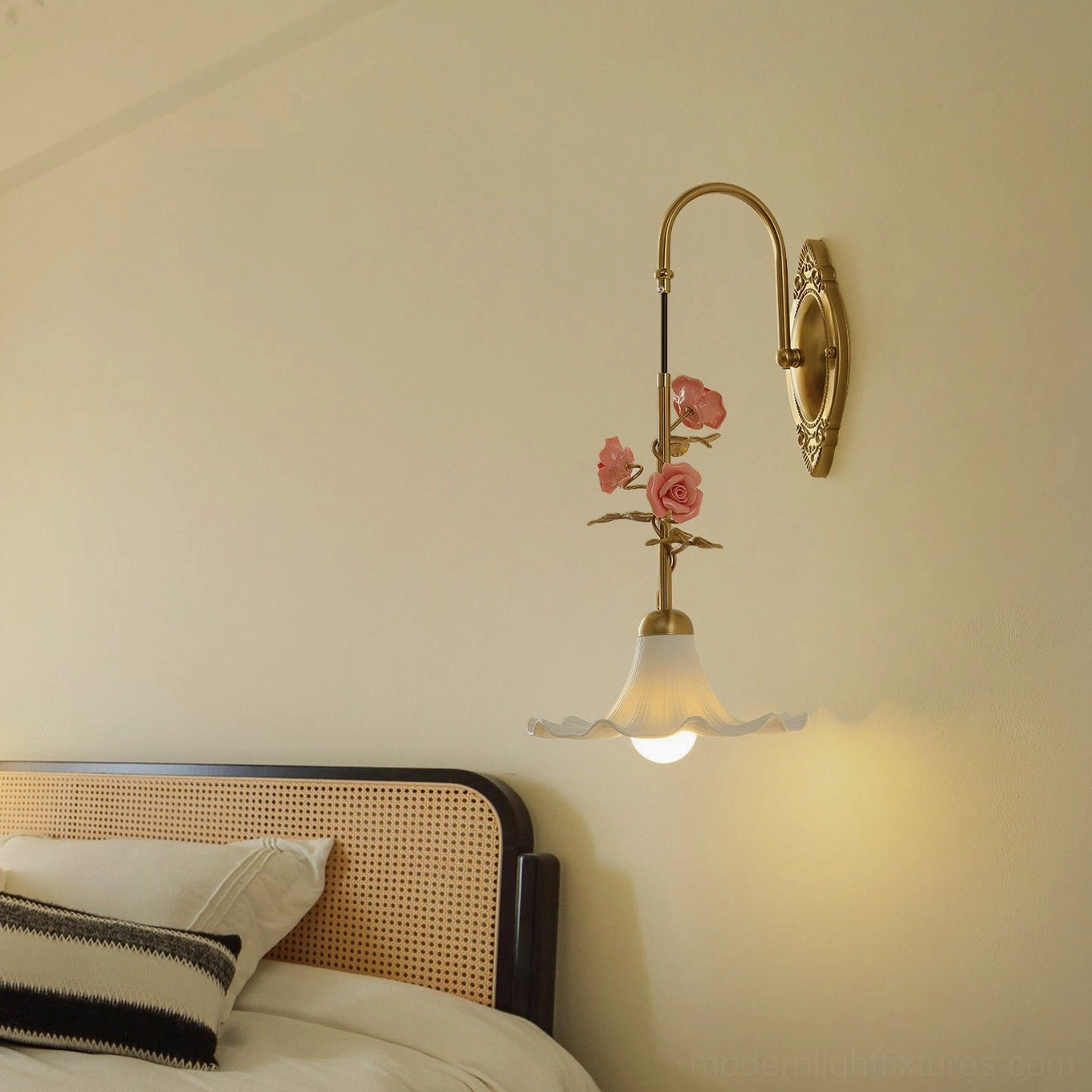 Ornella vintage-style wall lamp illuminated in bedroom setting with French provincial rattan headboard background
