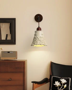 Ornella wall sconce installed in vintage bedroom, warm ambient lighting illuminating carved ivory shade against retro bedroom furniture