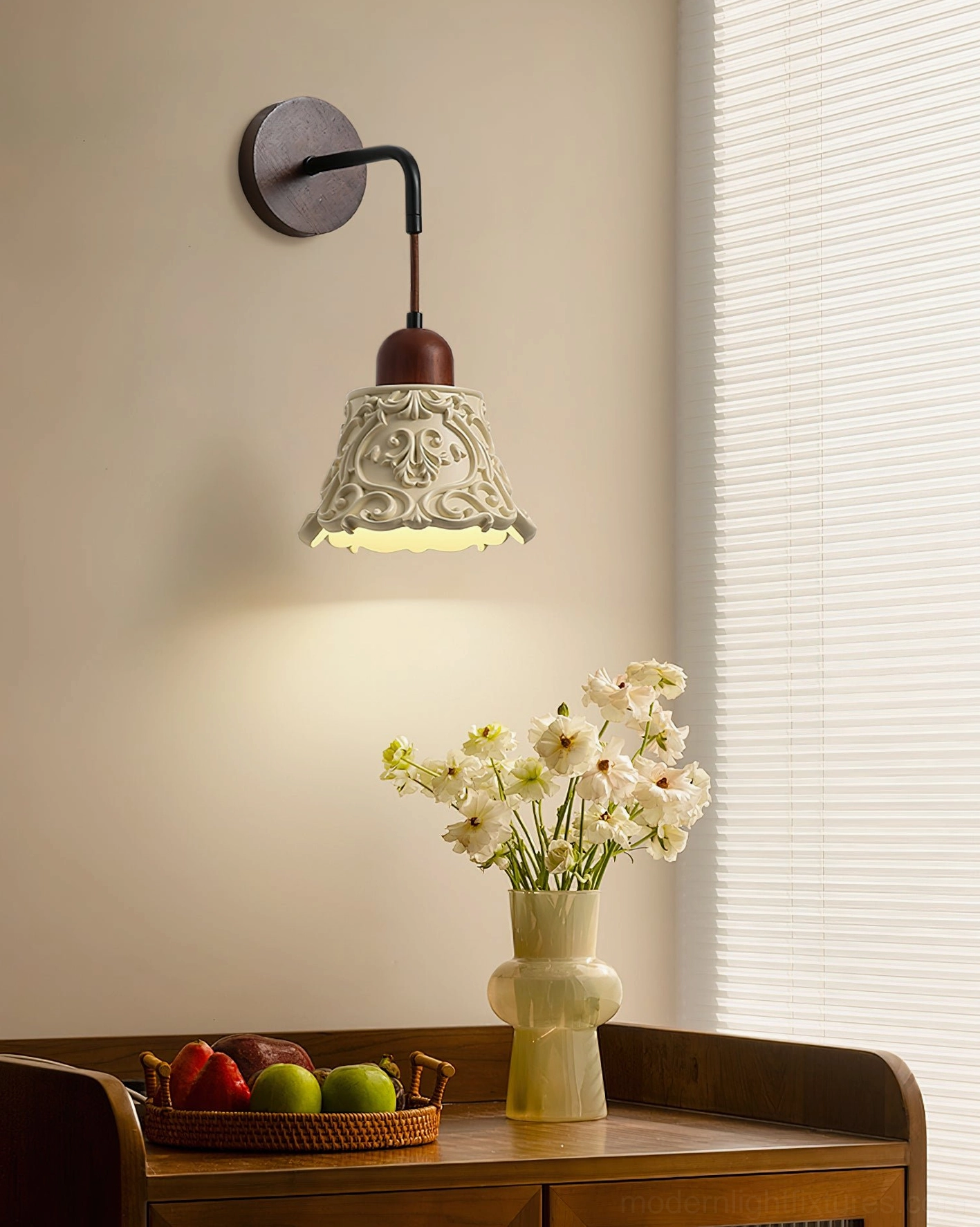 Ornella carved resin wall sconce in vintage dining area, warm floral-patterned shade illuminating wooden sideboard decor