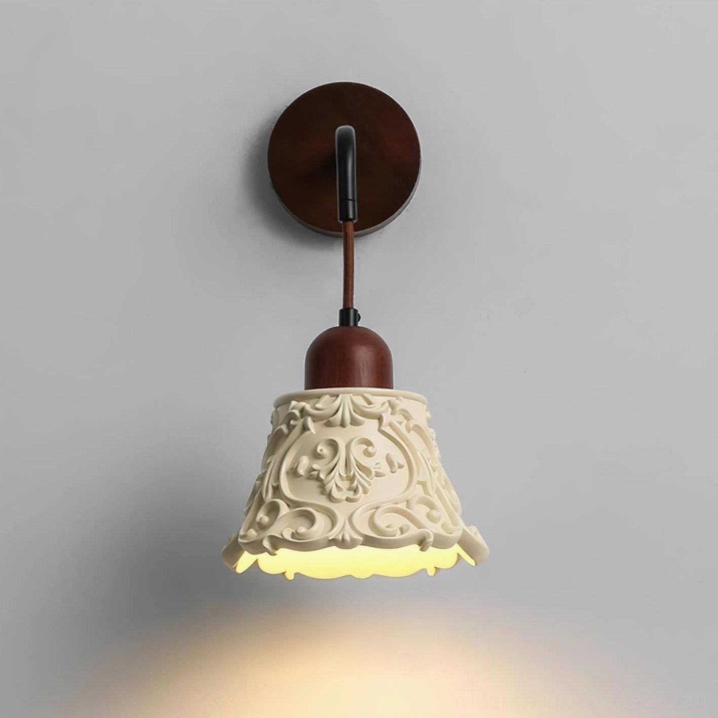 Ornella vintage wall sconce with warm light illumination, demonstrating softly diffused glow through carved resin