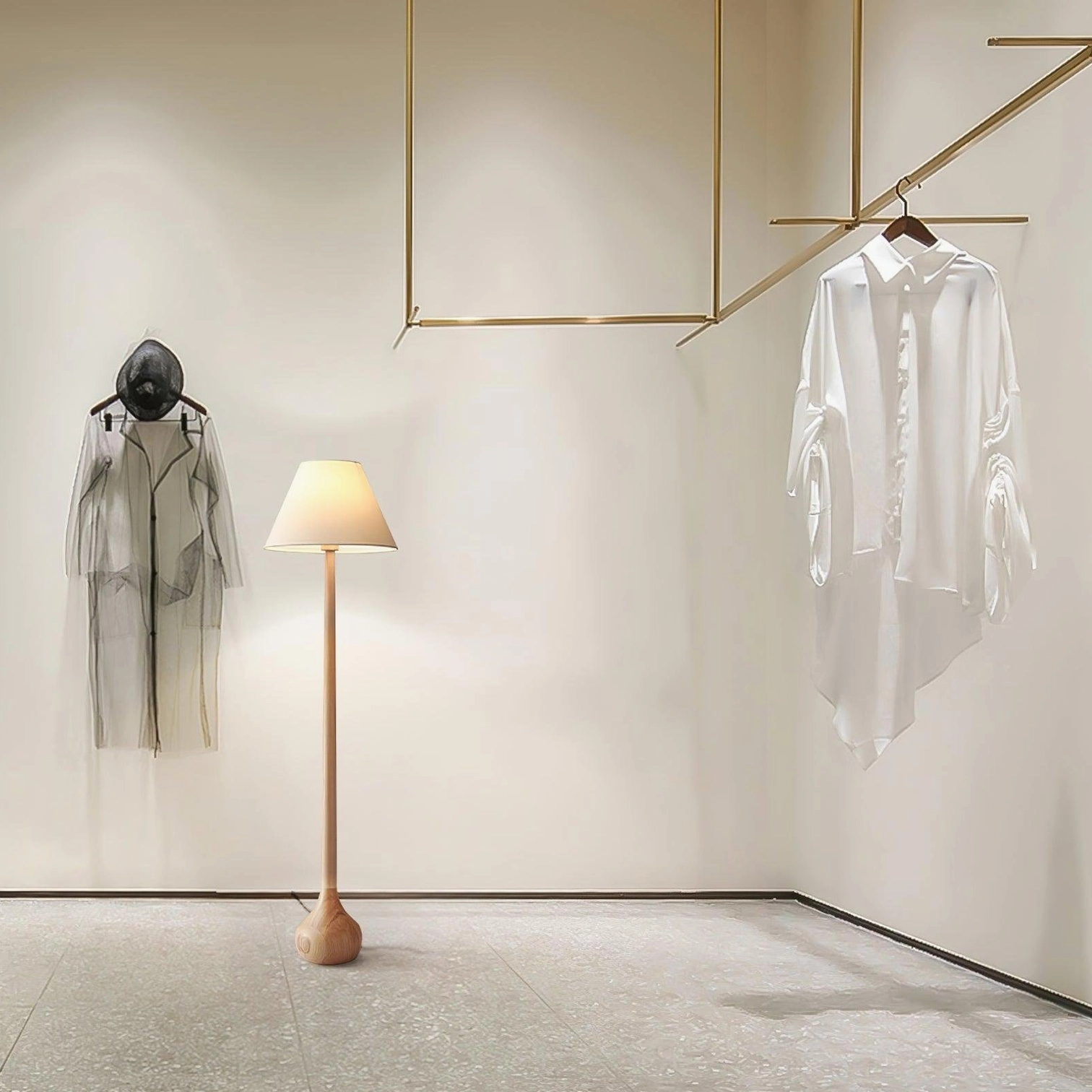Contemporary Osaka floor lamp with light tan wooden pole in minimalist garment display corner