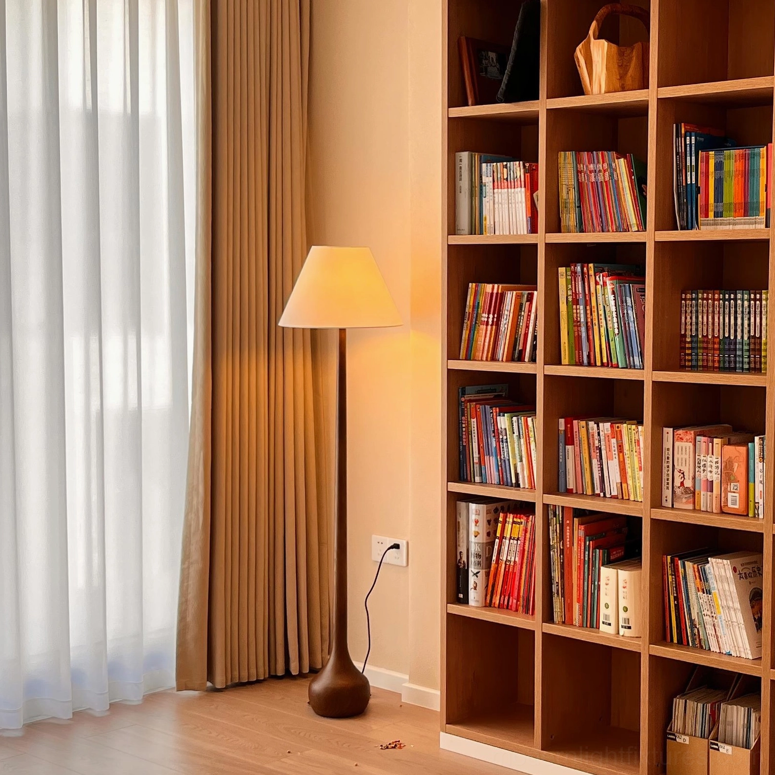 Contemporary Osaka floor lamp in home study with wooden bookshelf and dark brown wood pole