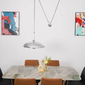 Contemporary dining room with Oscar pendant light fixture installed above marble table showcasing minimalist aesthetic