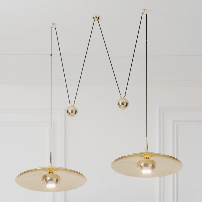 Oscar pendant light gold variant showcasing warm metallic finish and modern M-shaped silhouette design