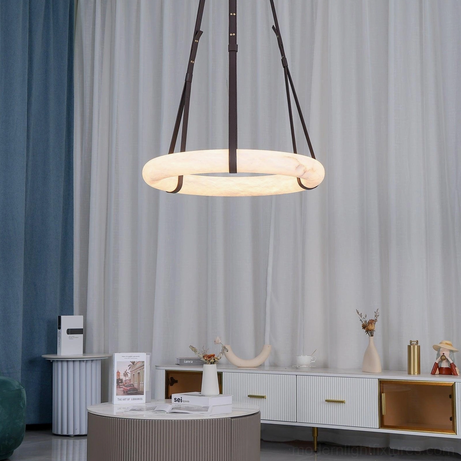 Oslo pendant light in modern residential living room with dark leather straps and diffused alabaster shade, wide side view