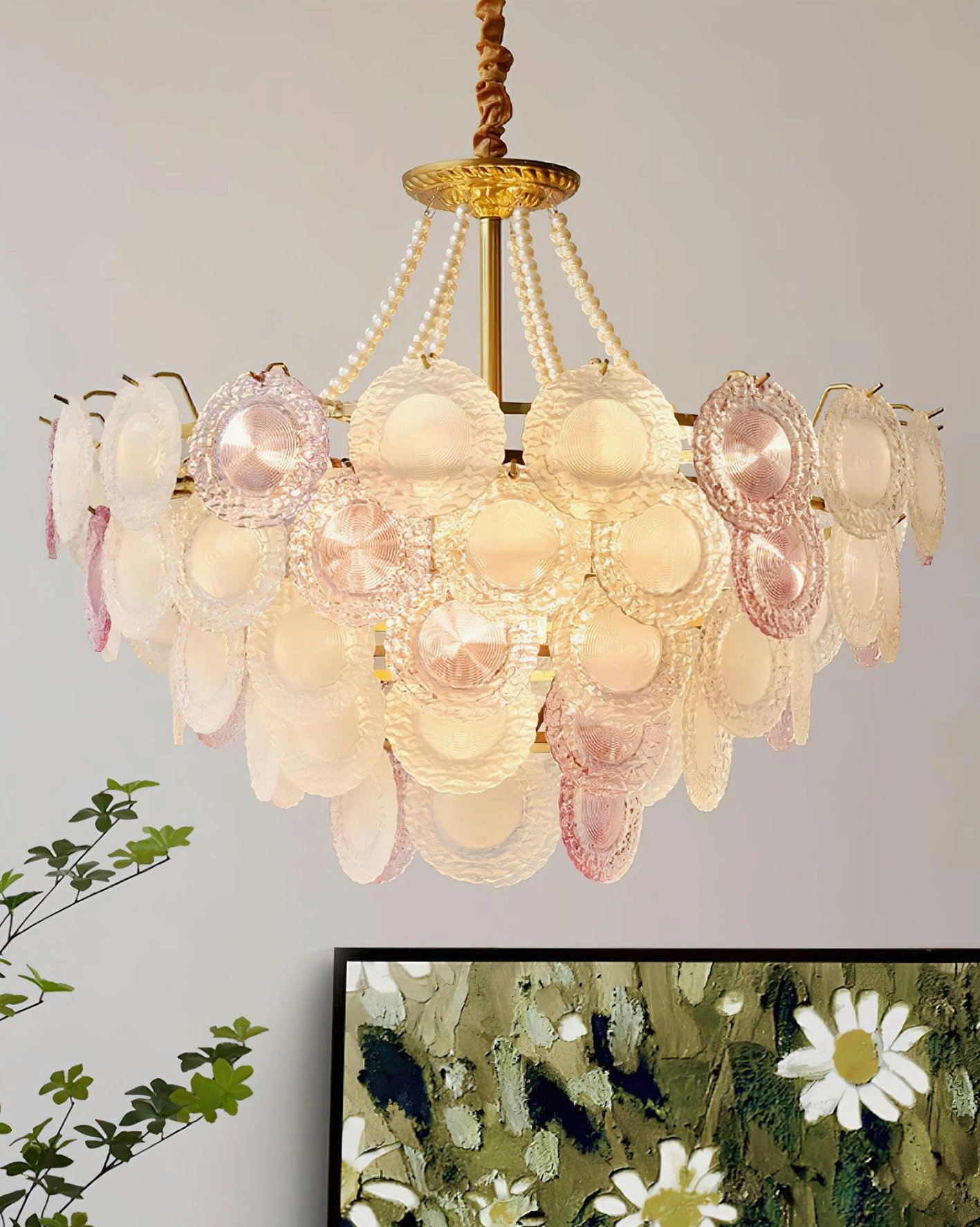 Violaire chandelier overhead interior view in living room with warm ambient illumination and plant decor accents