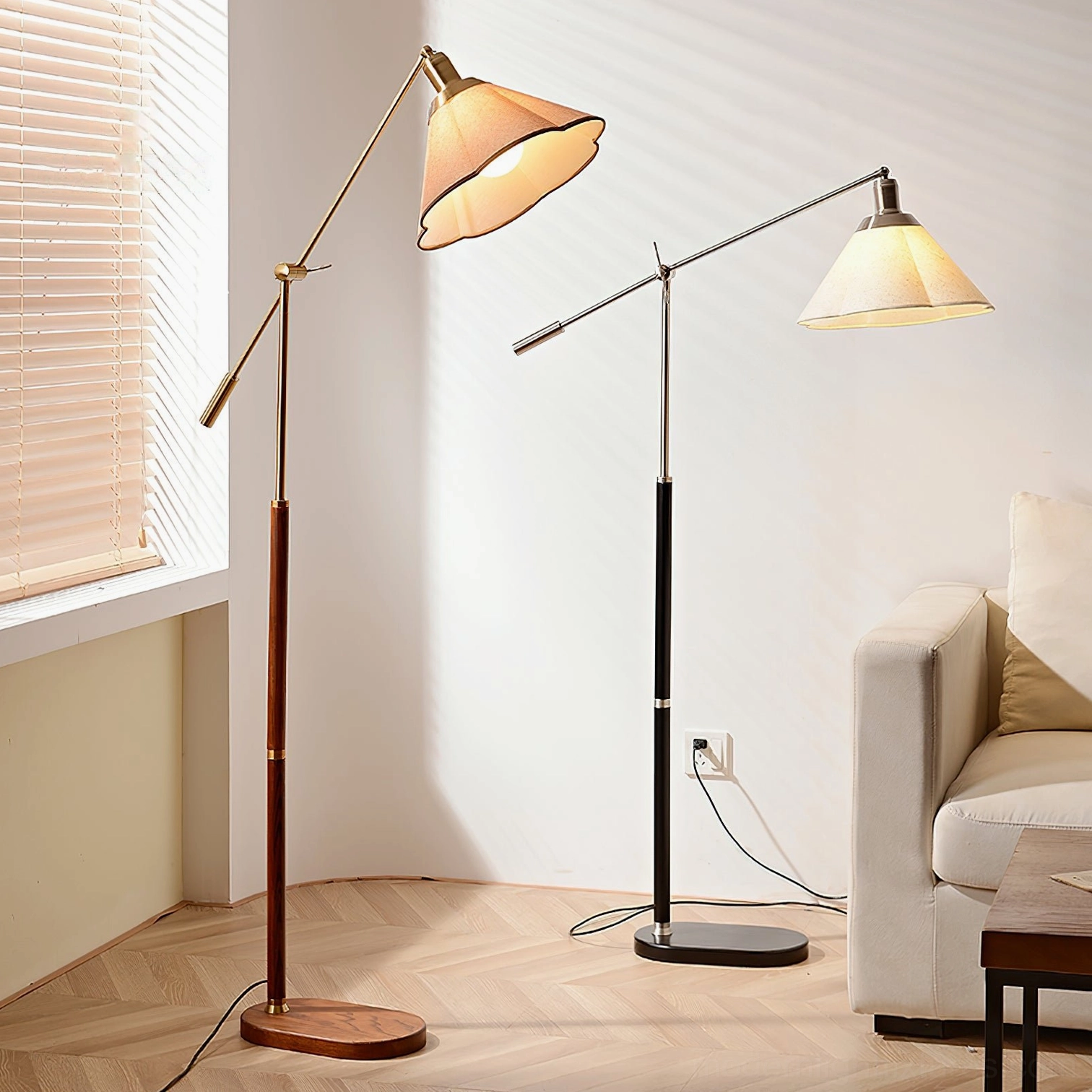 Pair of swing arm floor lamps styled together in residential living room, one walnut wood and one black metal with matching hardware