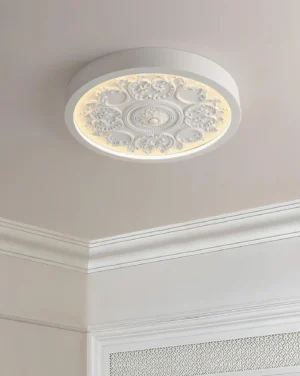Palais Ring round flush mount ceiling lamp installed in minimalist white interior with crown molding, glowing warm white neoclassical floral medallion