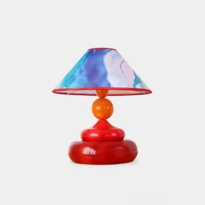 Paloma artistic table lamp with red ceramic base and watercolor fabric shade on white background, retro playful design with glossy ceramic finish