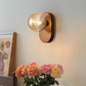 Modern ribbed glass wall lamp displayed with vintage floral decor in warm home setting