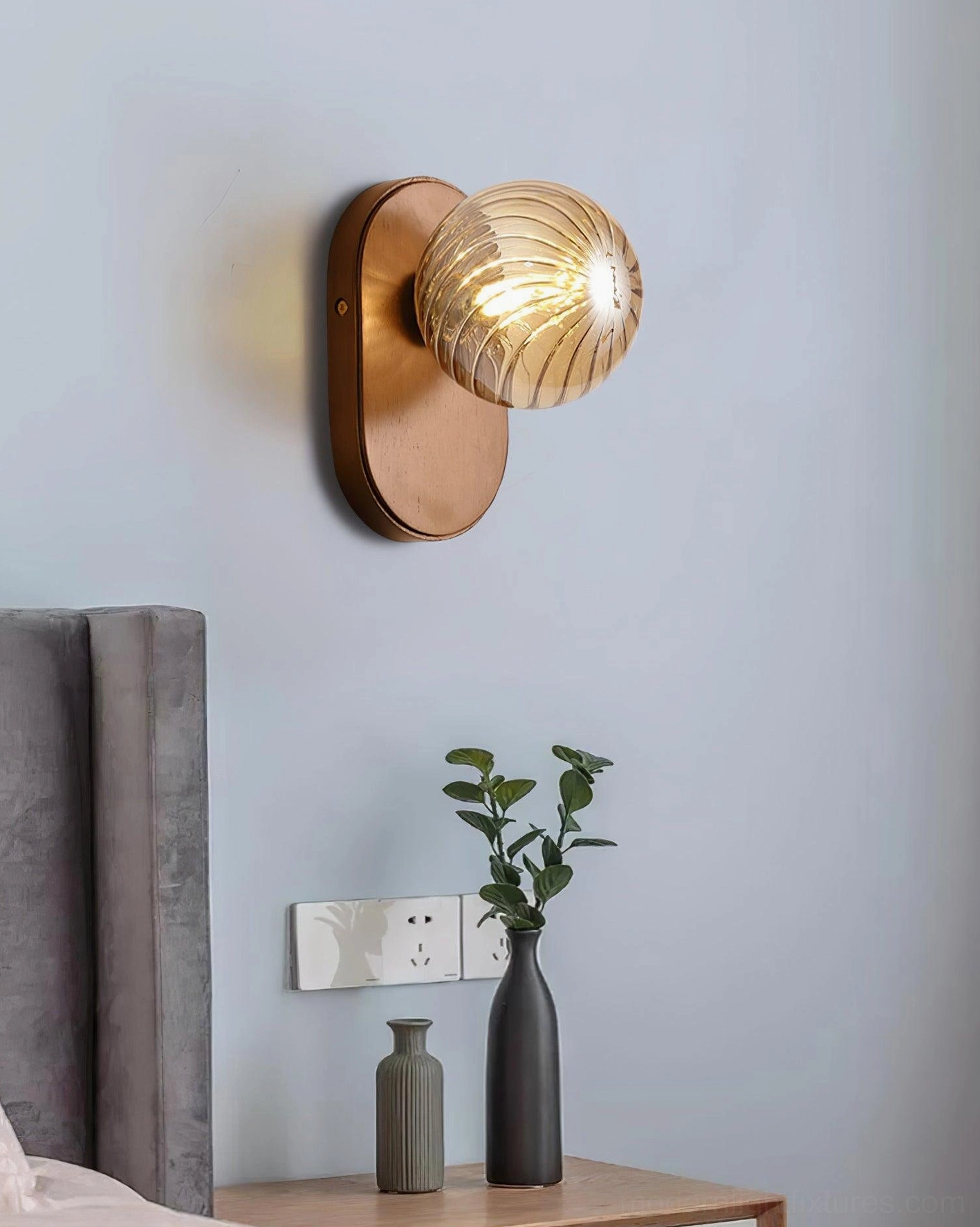 Paola wall sconce installed above wooden bedside table in calm neutral bedroom aesthetic