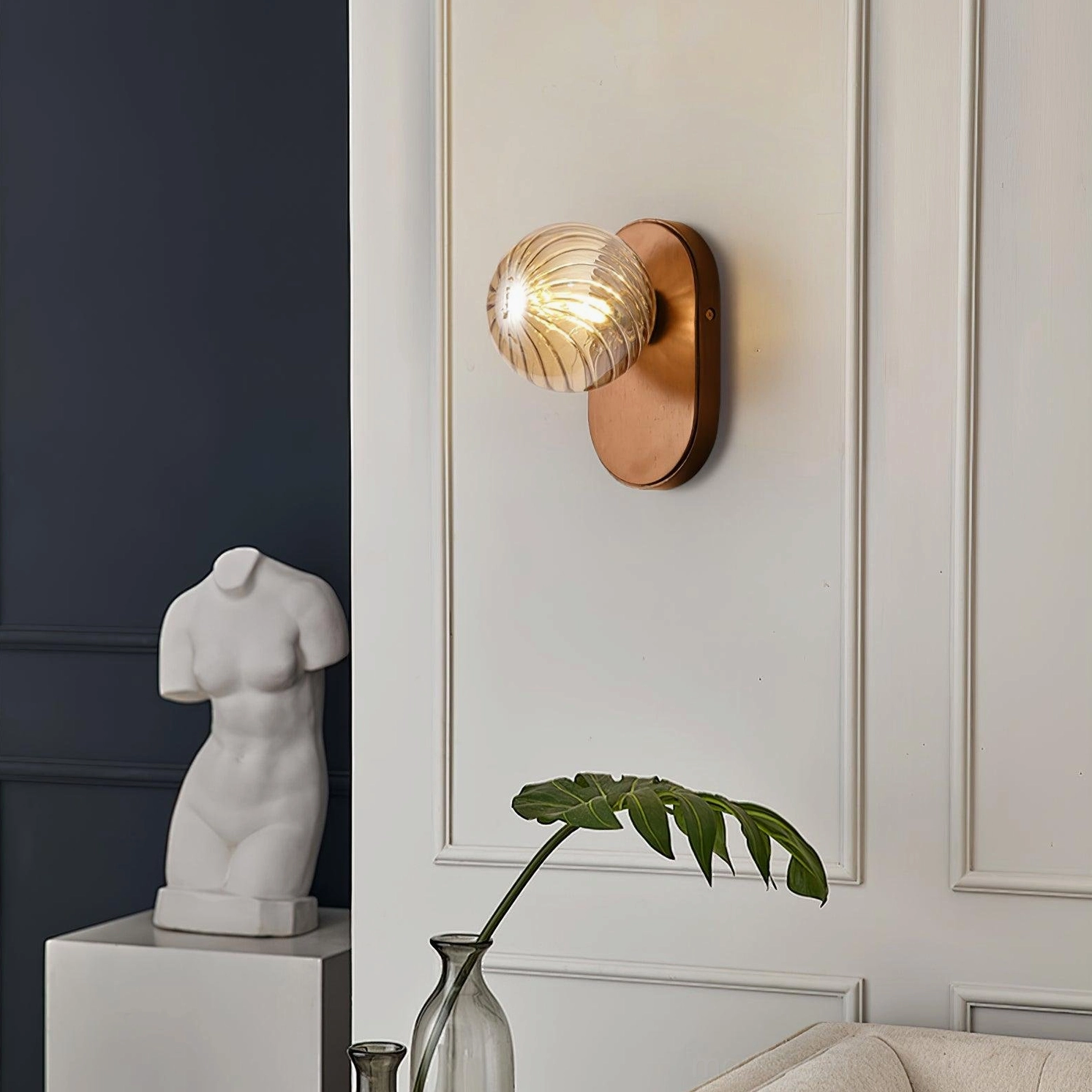 Paola ambient wall sconce showing warm diffused lighting through ribbed glass globe