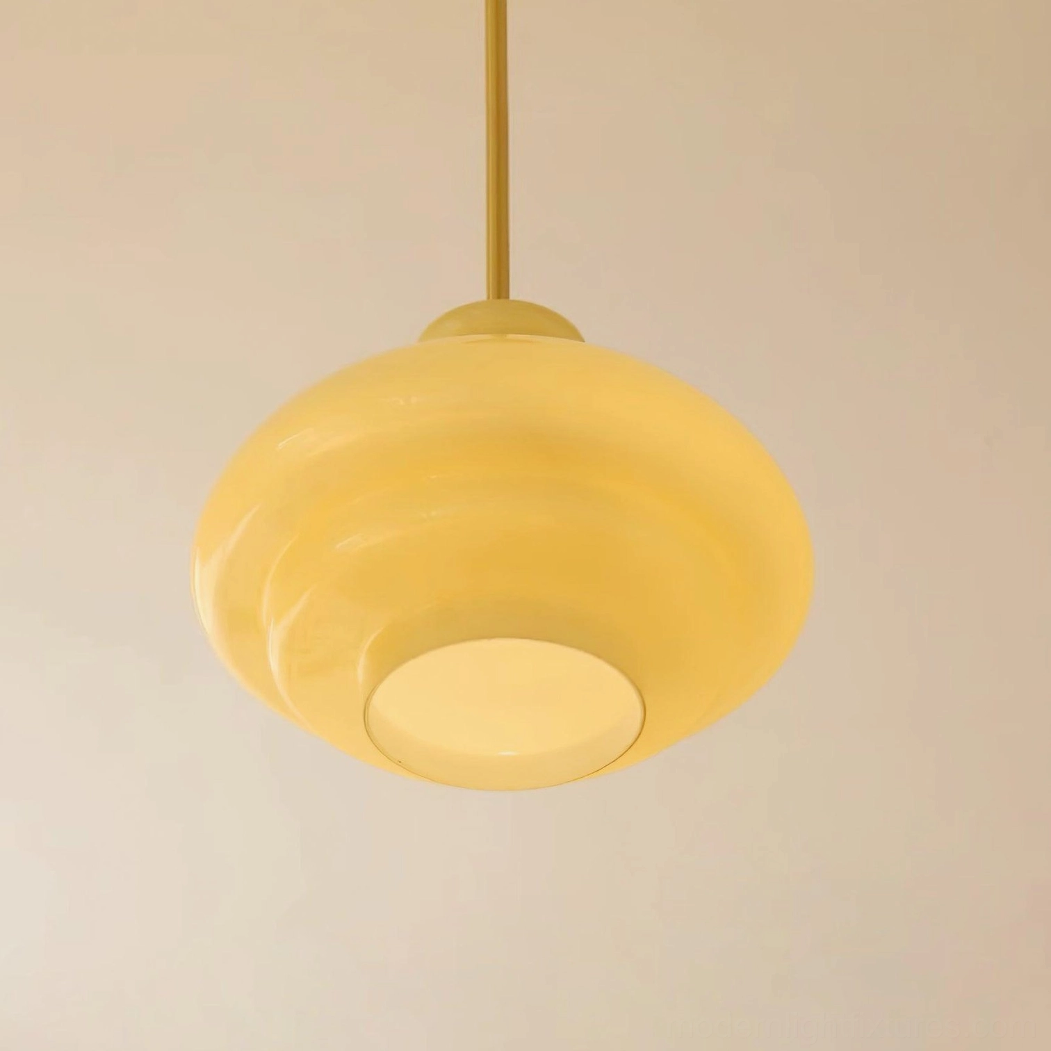 Paolina tiered glass pendant light illuminated, showing warm light diffusion through frosted glass shade in home dining space