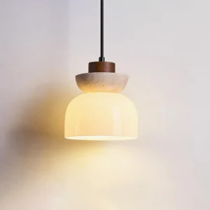 Paolina pendant light illuminated with warm amber glow through frosted glass dome, beige travertine and white wood combination